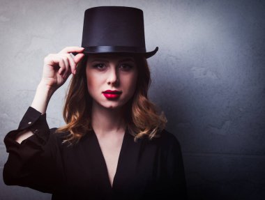 Silindir şapka gri arka plan üzerinde stil ve gizemi Kızıl saçlı kız