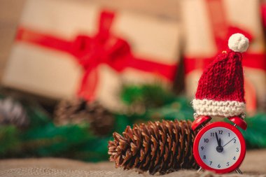 Noel Baba şapkası jüt ve arka plan üzerinde Noel hediyeleri ile çalar saat