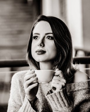 çay veya kahve sabah zamanında balkon oturan güzel kızıl saçlı kadın. Görüntü siyah beyaz renk tarzı