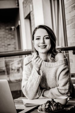 Güzel genç iş kadını açık havada evde otururken dizüstü bilgisayarda çalışıyor. Başlangıç iş ile iş kavramı. Görüntü siyah beyaz renk tarzı