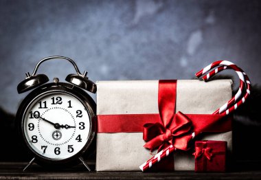 Noel hediyesi ile gri arka plan üzerinde lolipop ile ilmek ve retro çalar saat