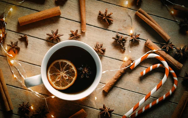 Tasse Tee Und Lutscher Mit Weihnachtlichen Zutaten Auf Holzgrund — Stockfoto