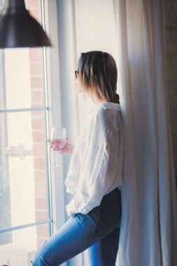 Cam bir mutfak bir şarap fiyatının beyaz Bayan beyaz gömlek ve mavi jeans.