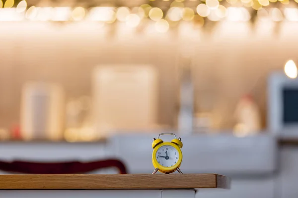Kleiner Wecker Auf Einem Tisch Mit Weihnachtsbeleuchtung Hintergrund Kücheneinrichtung — Stockfoto