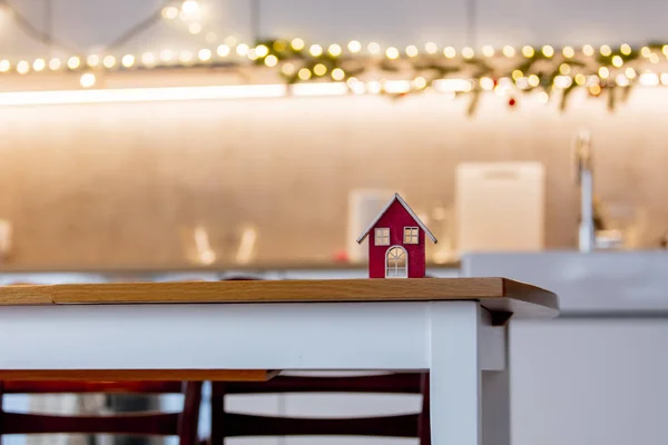 Kleines Rotes Haus Auf Einem Tisch Einer Küche Mit Weihnachtsbeleuchtung — Stockfoto