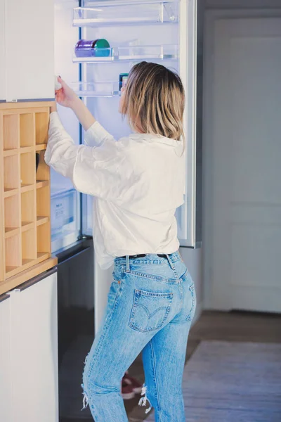 Joven Mujer Caucásica Camisa Blanca Vaqueros Azules Permanecer Cerca Refrigerador —  Fotos de Stock