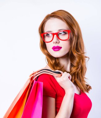 beyaz zemin üzerinde alışveriş torbaları ile Kızıl saçlı kız