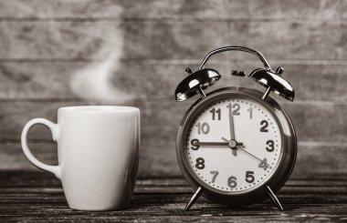 Fincan kahve ve ahşap masa çalar saat. Görüntü siyah beyaz renk tarzı
