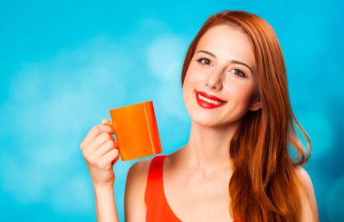 Kızıl saçlı kadın kahve üzerinde mavi arka plan ile.