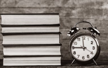 Çalar saat ve ahşap masa kitap. Görüntü siyah beyaz renk tarzı