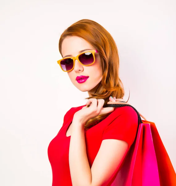 白い背景の上の買い物袋で赤毛の女の子 — ストック写真