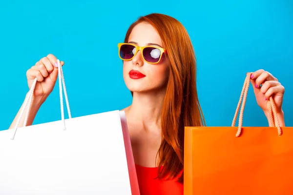 Estilo Mujer Pelirroja Sosteniendo Bolsas Compras Sobre Fondo Azul —  Fotos de Stock