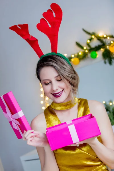 Mujer en cuernos de renos de Navidad y caja de regalo — Foto de Stock