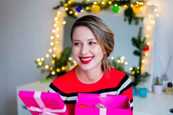 Hermosa mujer en suéter rojo sosteniendo una caja de regalo — Foto de Stock