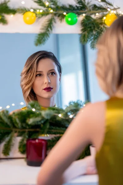 Жінка застосовує косметику біля прикрашеного дзеркала — стокове фото