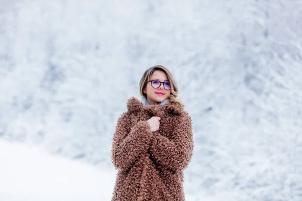 Vacker flicka i pälsen i en snö skog — Stockfoto