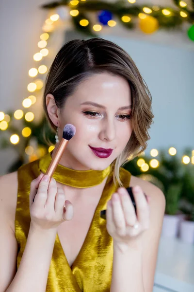 Mujer aplicando cosméticos cerca de espejo decorado — Foto de Stock