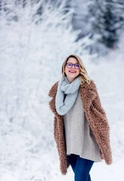 Vacker flicka i pälsen i en snö skog — Stockfoto