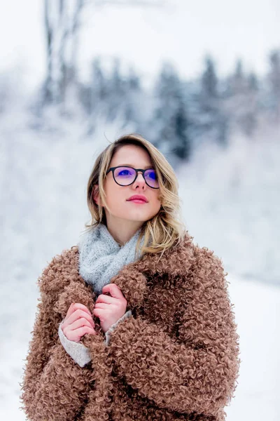 Vacker flicka i pälsen i en snö skog — Stockfoto