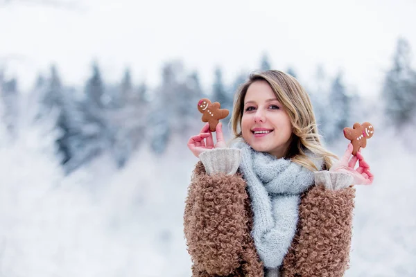 Vacker flicka i rock med kaka i en snöskog — Stockfoto