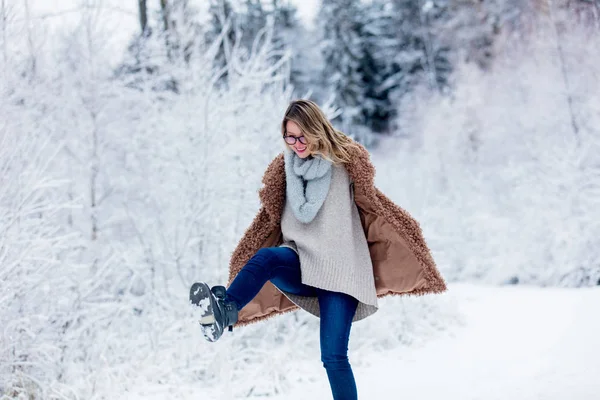 Vacker flicka i pälsen i en snö skog — Stockfoto