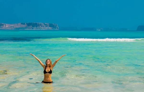 Junge rothaarige Mädchen im schwarzen Bikini am Strand von Balos — Stockfoto