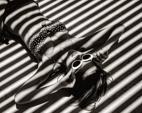 Menina deitada em um chão com sombras . — Fotografia de Stock