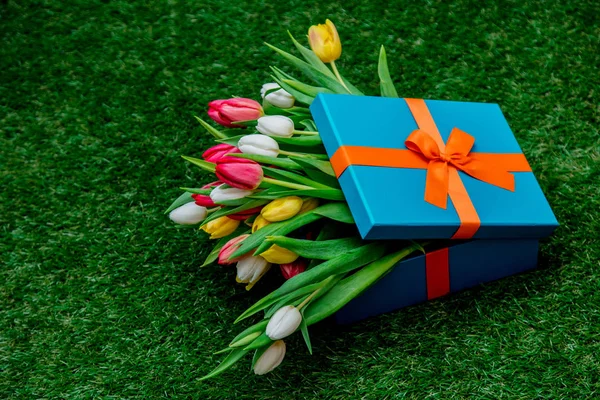 Scatole regalo e tulipani sul prato verde erba — Foto Stock