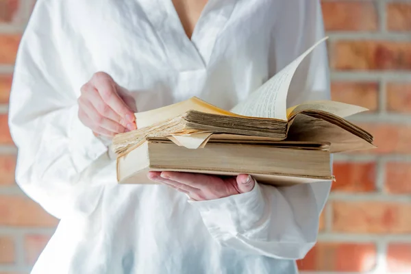 Frau im weißen Hemd hält altes Buch in der Hand — Stockfoto