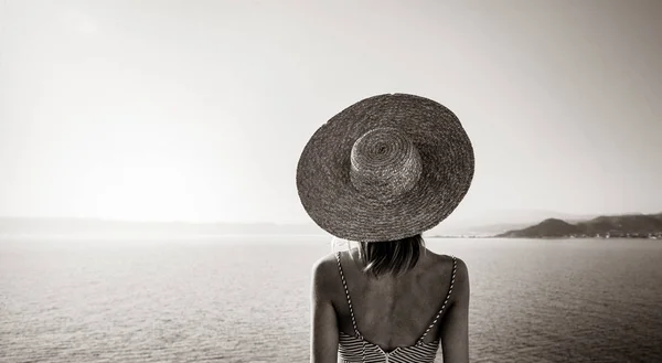 Дівчина в капелюсі і в сукні з морським узбережжям — стокове фото
