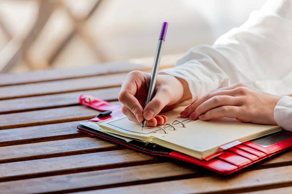 Main avec stylo écrire quelque chose dans un carnet — Photo