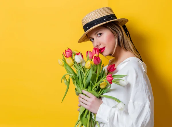 Mulher de camisa branca e chapéu com tulipas frescas da primavera — Fotografia de Stock