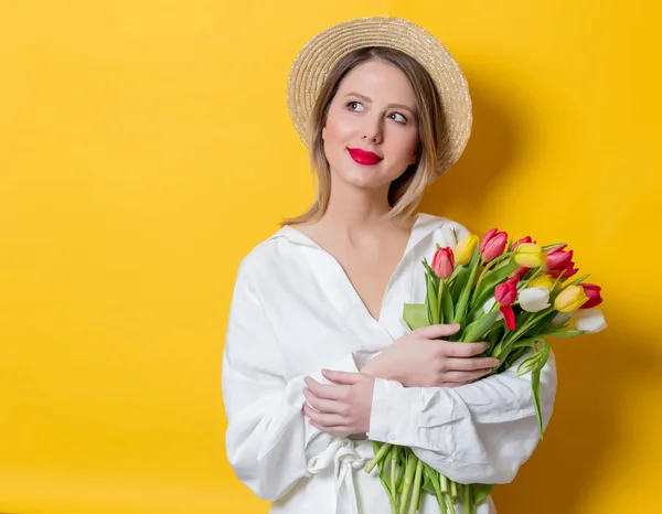 Mulher de camisa branca e chapéu com tulipas frescas da primavera — Fotografia de Stock