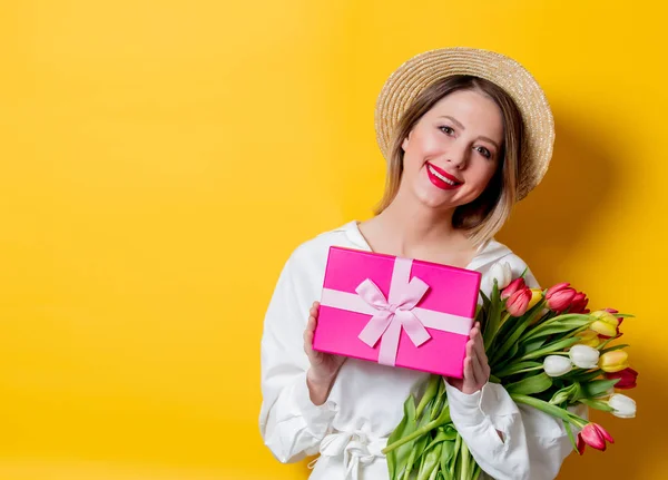 Vrouw met tulpen en geschenkdoos — Stockfoto