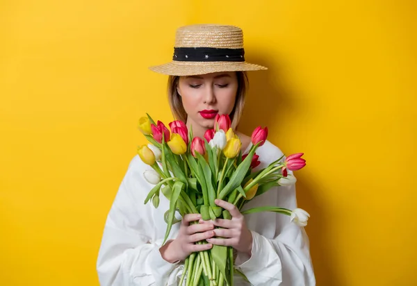 Mulher de camisa branca e chapéu com tulipas frescas da primavera — Fotografia de Stock
