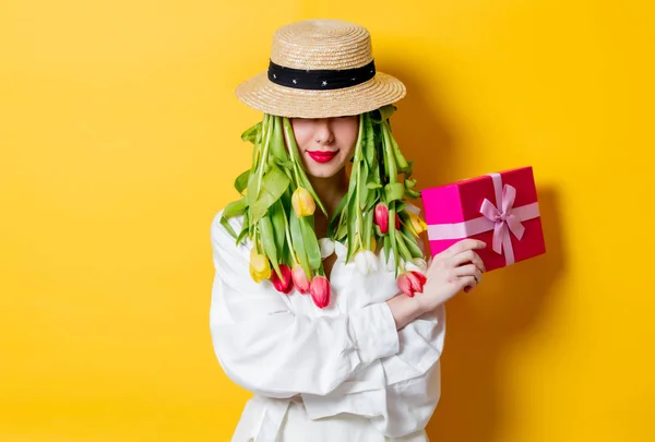 Donna in camicia bianca e cappello con tulipani freschi primaverili invece capelli — Foto Stock