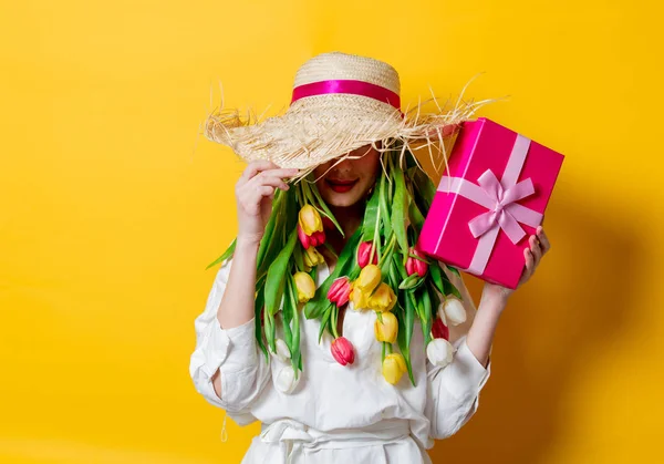 Donna in camicia bianca e cappello con tulipani freschi primaverili invece capelli — Foto Stock