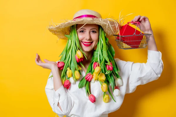 Mujer en camisa blanca y sombrero con tulipanes frescos de primavera y caja de compras —  Fotos de Stock