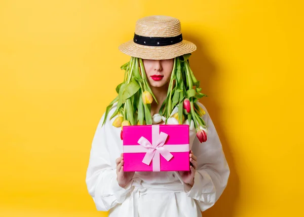 Mulher em camisa branca e chapéu com tulipas frescas primavera em vez de cabelo — Fotografia de Stock