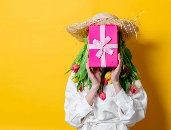 Donna in camicia bianca e cappello con tulipani freschi primaverili invece capelli — Foto Stock