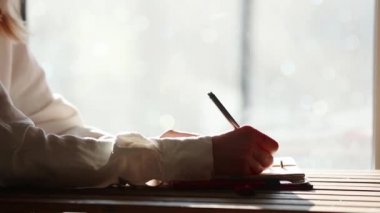 Kalemle bir şey not defterine yazma kadın.