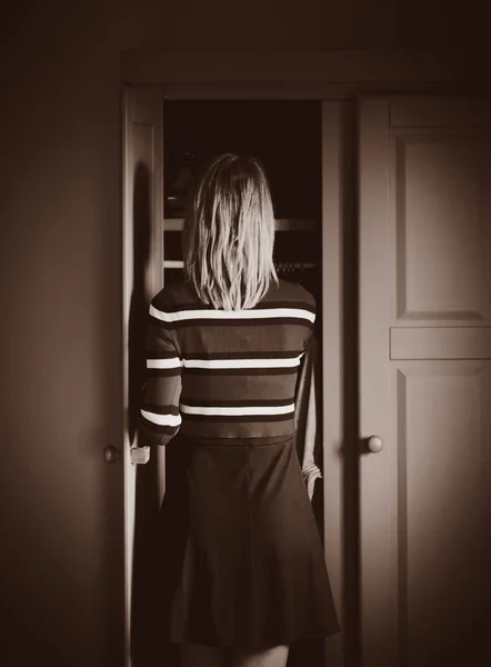Junges Mädchen wählt einen Pullover zu Hause in der Nähe von Kleiderschrank — Stockfoto