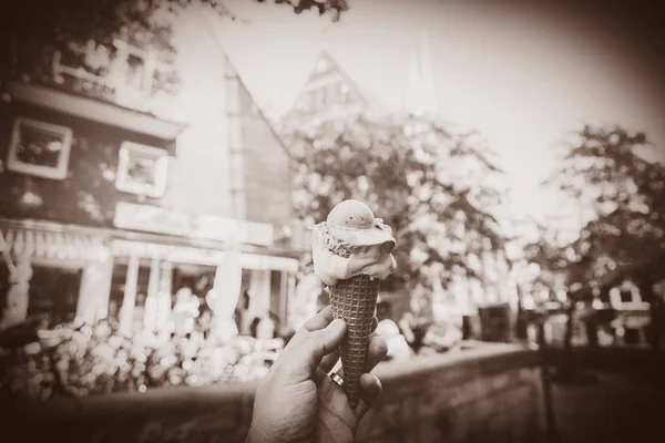 Mano masculina sosteniendo un helado con la calle de la ciudad —  Fotos de Stock