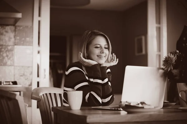 Молодая девушка смотрит на компьютер и ест — стоковое фото