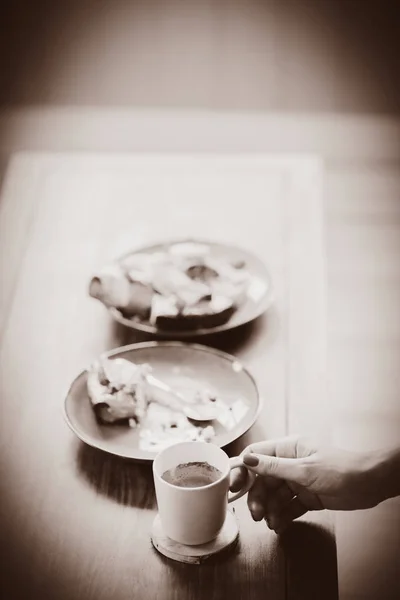 Hand halten Tasse in der Nähe Pastete mit Kuchen gegessen — Stockfoto