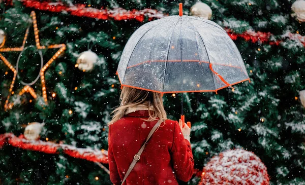 Tyttö sateenvarjo lähellä joulukuusi — kuvapankkivalokuva
