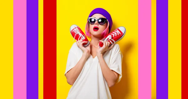 Meisje met roze haar bedrijf een rode gumshoes — Stockfoto