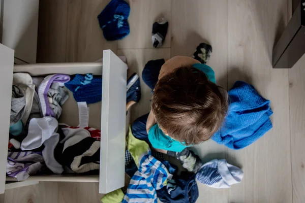 Мальчик играть с одеждой из шкафа — стоковое фото