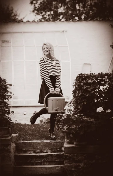 Girl water a flowers with watering can — Stock Photo, Image