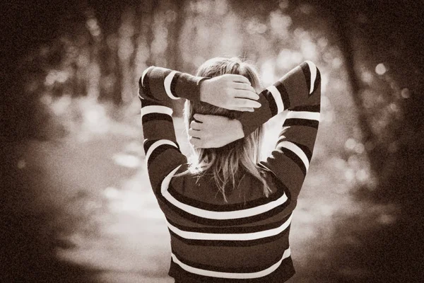 Back side of a girl in sweater in a park — Stock Photo, Image